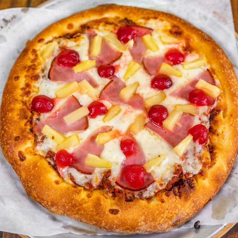 La Pizzeria's Hawaiian pizza with ham, pineapple, and cherries on a crispy crust.